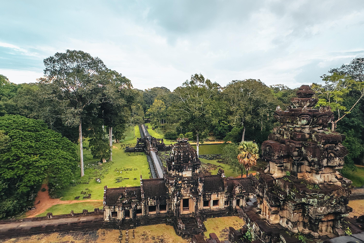 Traveler reading travel tips while standing near temple ruins