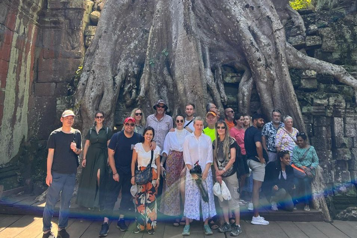Visitors exploring Bayon Temple with ancient stone faces in the background