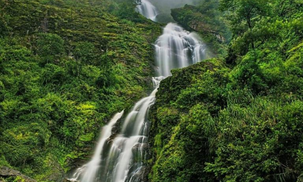 The waterfall cascades down the mountainside like a white silk ribbon
