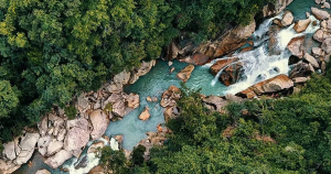 Scenic view of Ba Ho Waterfall surrounded by jungle and rocks in Nha Trang