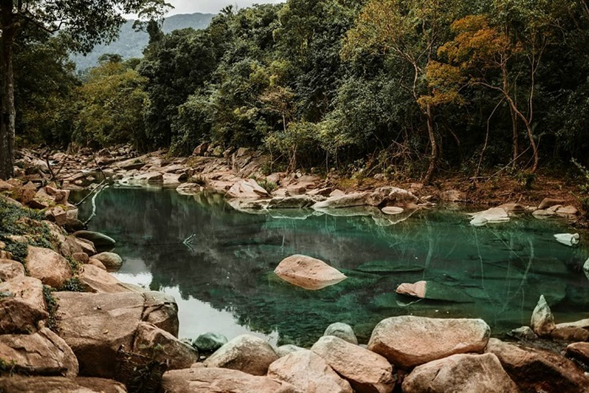 Tourists hiking and swimming in Ba Ho Waterfall natural pools