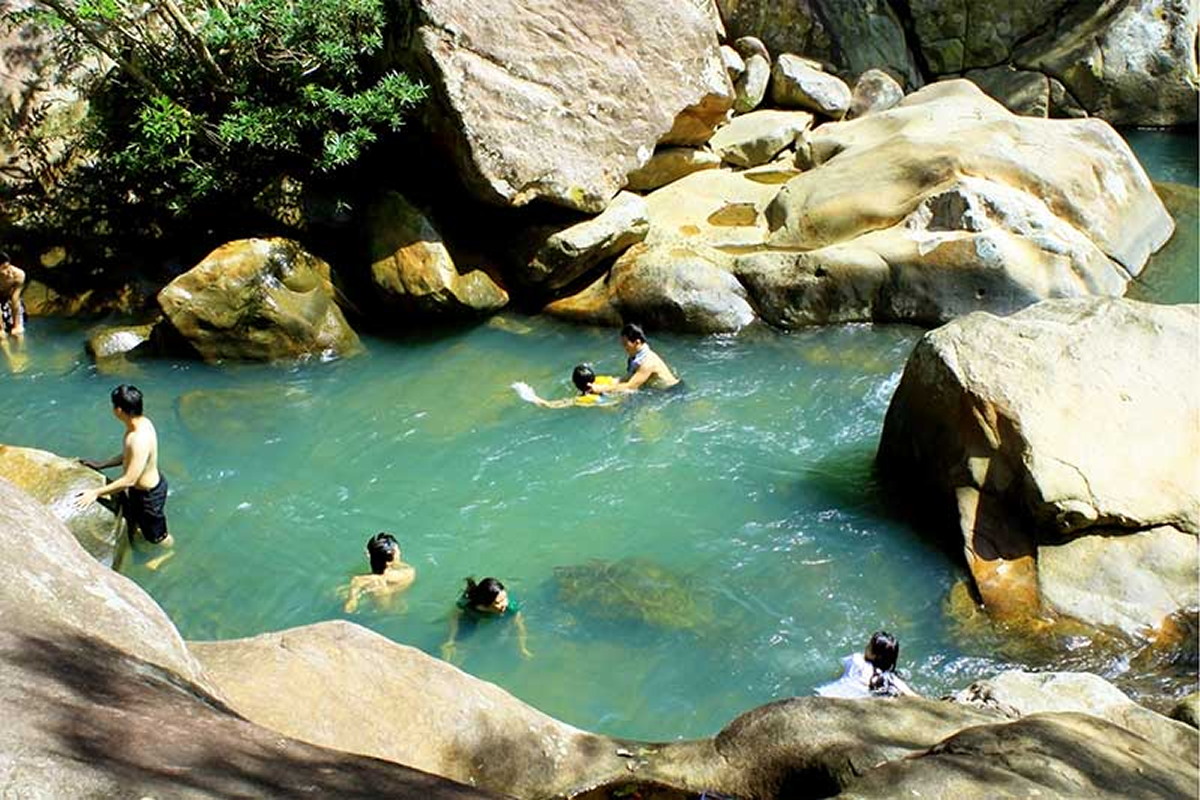 Entrance area of Ba Ho Waterfall tourist site with signage