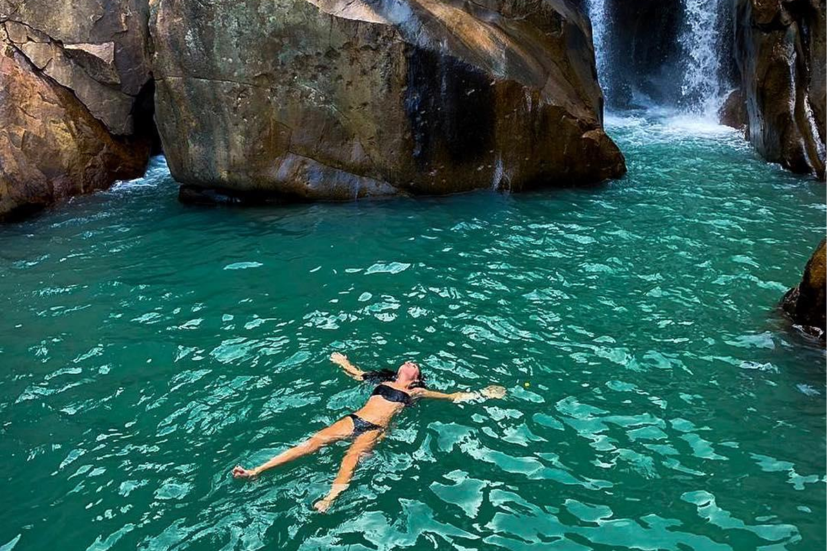 Tourists swimming in the first natural pool at Ba Ho Waterfall